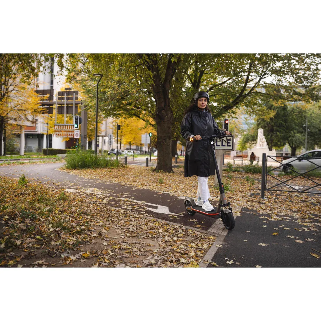 Une conductrice casquée roule sur la XLD900E sur une piste cyclable bordée d'arbres en automne
