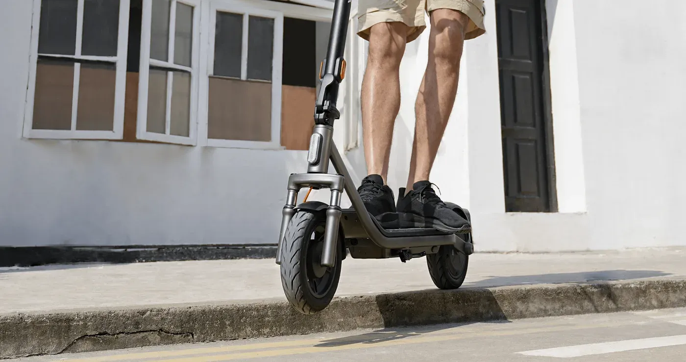 Conducteur sur une Xiaomi Electric Scooter 6 Lite qui descend une bordure de trottoir en ville